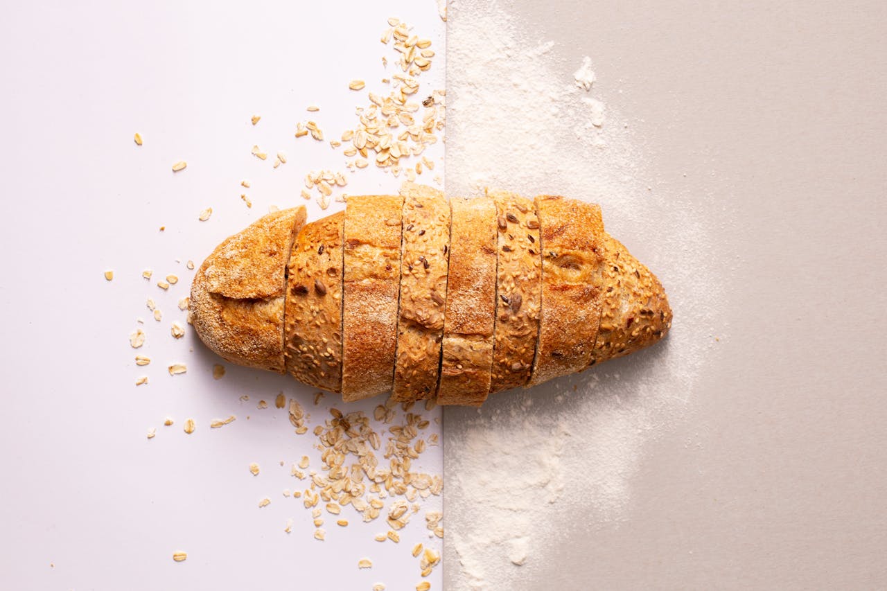 Freshly sliced whole grain bread with oats and flour provides a rustic and nutritious appeal.